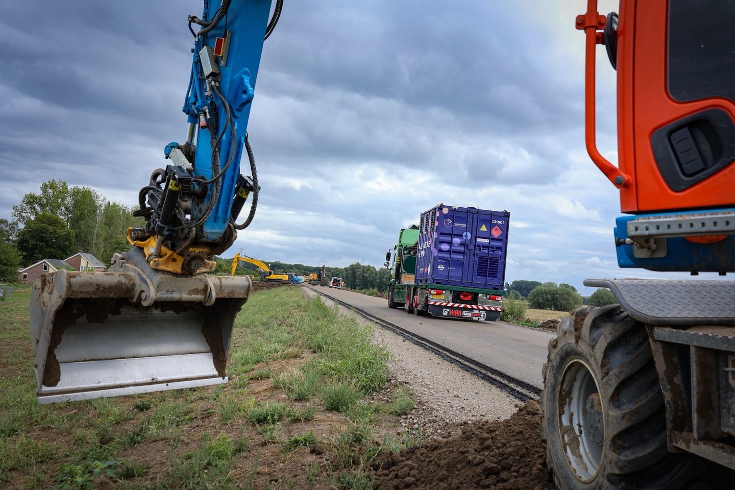 Vrachtwagen met een Powercrumbs-unit op een bouwweg tussen graafmachines